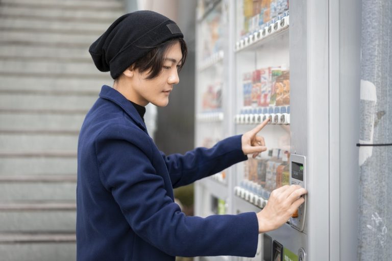 side-view-man-ordering-from-vending-machine